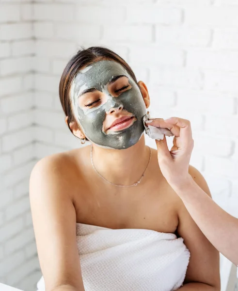 Potret seorang wanita cantik menerapkan masker wajah melakukan prosedur spa — Stok Foto