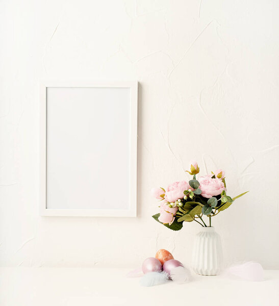 Easter holiday. Mock up frame on the wall with peonies and colored eggs