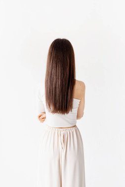 Hafif ve havadar. Beyaz arka planda beyaz, uzun saçlı, güzel, genç bir kadın.