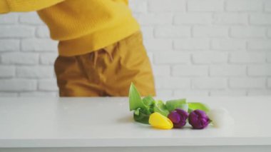 Masaya renkli laleler koyan kadın. tuğla arkaplan