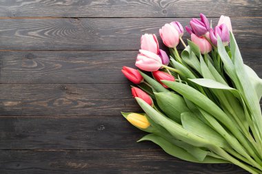 Bahar konsepti Siyah ahşap arkaplanda fotokopi alanı olan lale buketi