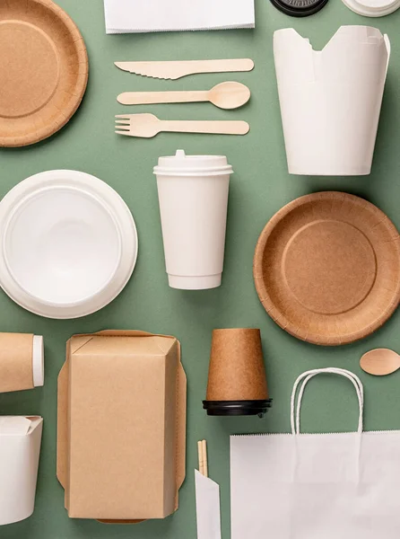 Knolling concept. Eco friendly zero waste disposable tableware top view flat lay on green background. Pattern
