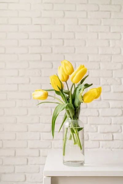 Bouquet Tulipani Gialli Vaso Vetro Uno Sfondo Muro Mattoni Bianchi — Foto Stock