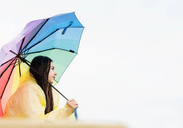 Beautiful Smiling Brunette Woman Yellow Raincoat Holding Rainbow Umbrella Out — Stock Photo, Image