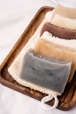 Doğal organik kozmetik. Beyaz zemin üzerinde ahşap tepside el yapımı sabun yığını