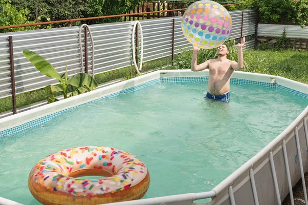 Молодой Кавказский Мужчина Развлекается Бассейне Играет Разноцветным Надувным Мячом — стоковое фото