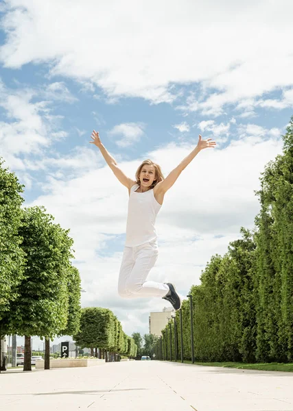 白いTシャツの幸せな若い女性がジャンプし 公園で叫んでいる デザインを模倣し — ストック写真