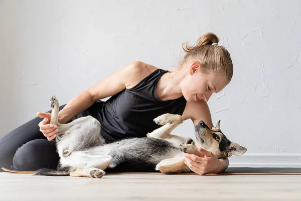 Jovem mulher esportiva abraçando seu cão de raça mista — Fotografia de Stock