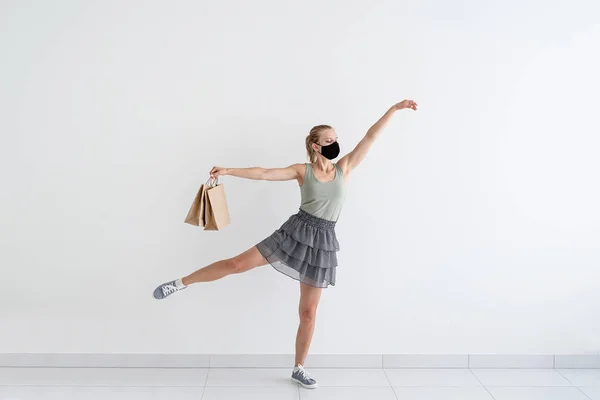 卫生保健和检疫概念 戴着防护面具戴着购物袋跳芭蕾舞的年轻女子 — 图库照片