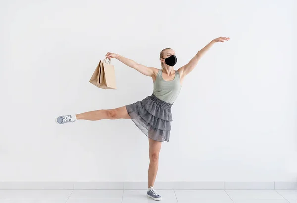 卫生保健和检疫概念 年轻女子戴着防护面具 戴着购物袋跳芭蕾舞 在隔离和隔离状态下购物 — 图库照片