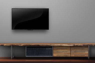 TV gri renk duvarda ahşap masa ile açtı.