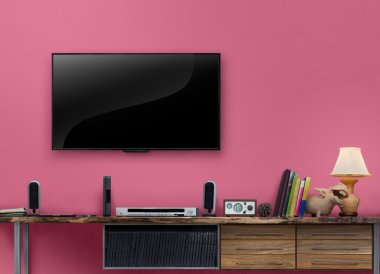 TV ahşap masa oturma odası pembe duvarda ışık saçtı