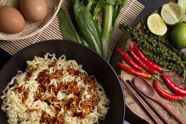 mutfak masasının üstünde süslenmiş siyah kase erişte