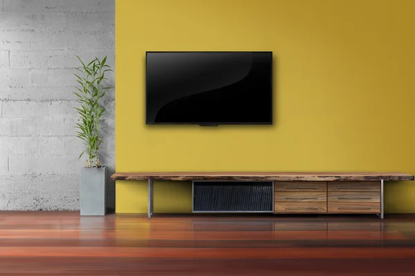 Oturma odasında tv sarı duvarda ahşap masa medya furnit ile led
