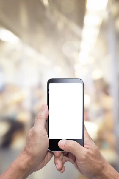 Mãos segurando e usando a tela em branco do smartphone no fundo desfocado — Fotografia de Stock