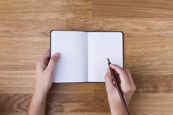 Hand with pen writing on blank notepad — Stock Photo, Image