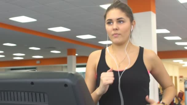 Fille travaillant dans un tapis roulant à la salle de gym — Video