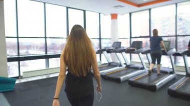 Spor salonunda bir koşu bandı içinde çalışma dışarı kız
