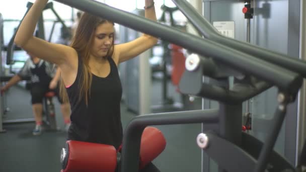 Hermosa joven haciendo ejercicios para fortalecer el simulador de hombro — Vídeo de stock