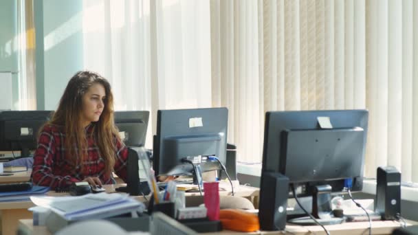 Menina bonita sentada no escritório e falando ao telefone — Vídeo de Stock