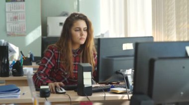 ofis ve kameraya gülümseyen güzel kız çalışır