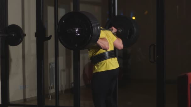 De man met een barbell squats — Stockvideo