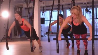 3 kız fitness salonunda egzersiz yaparak