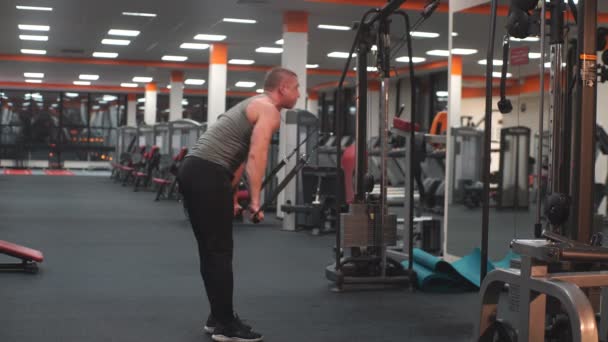 Мужчина делает многофункциональные упражнения в симуляторе — стоковое видео