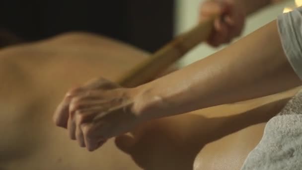 Woman getting a back massage with a bamboo stick — Stock Video