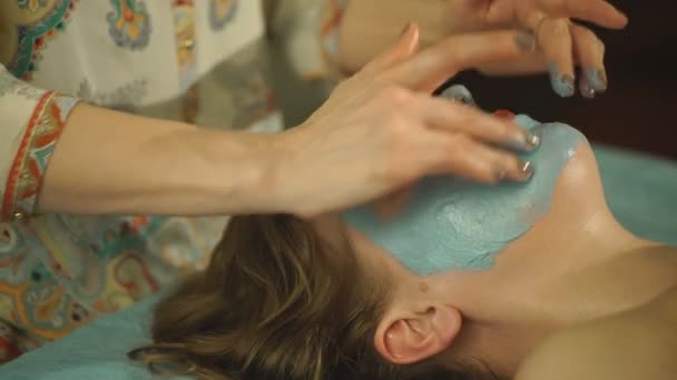 De vrouw maken een gezichtsmasker uit klei — Stockvideo
