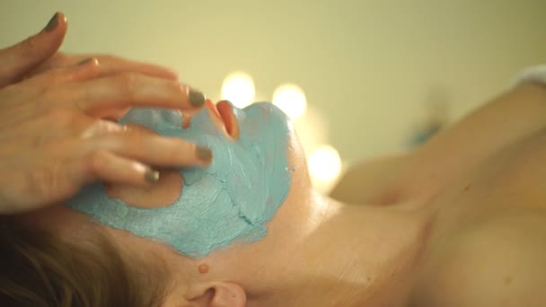 Kvinnan gör en ansiktsmask av lera — Stockvideo