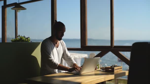 Açık kafede çalışan dizüstü bilgisayar ile genç adam — Stok video