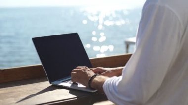 Deniz arka plan üzerinde laptop Rıhtımlar üzerinde bilgi arayan adam