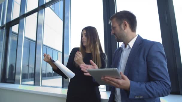 Businesswoman and businessman standing in office and discuss the business plan — Stock Video