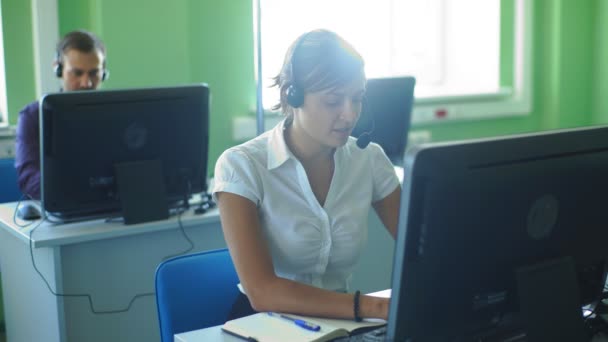 Jeune femme d'affaires travaillant dans un centre d'appels avec ses collègues — Video