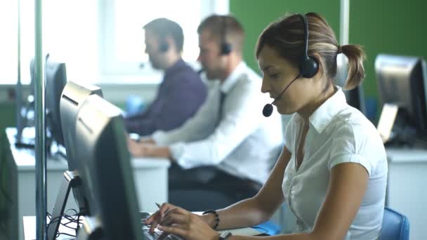 Grupo de colegas de negocios con auriculares que utilizan computadoras en el escritorio de la oficina — Vídeo de stock