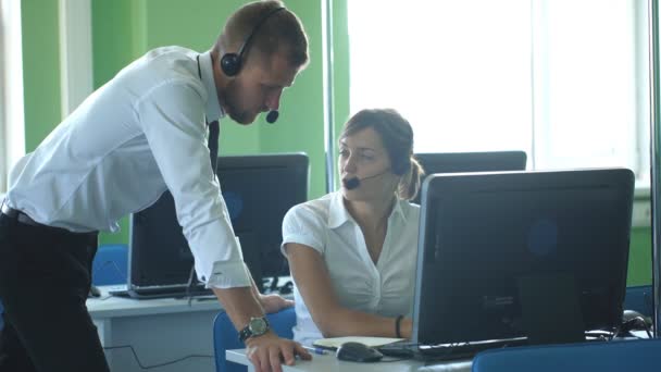 Operatore telefonico che lavora all'ufficio del call center per aiutare il collega sibilante. — Video Stock