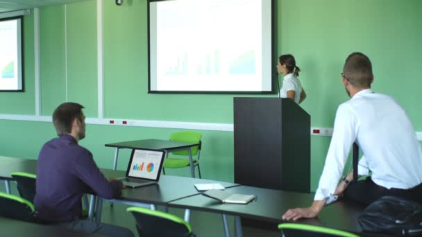 Joven mujer de negocios mostrando una presentación a sus colegas — Vídeo de stock