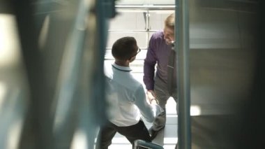 Gülümseyen ve bir ofis lobisinde el sıkışan iki iş adamları