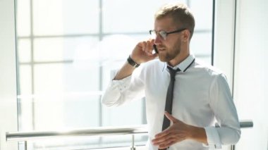 genç işadamı ofisinin lobisinde telefonda konuşuyor