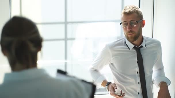 Hombres de negocios exitosos discutiendo plan de negocios cerca de la ventana — Vídeos de Stock