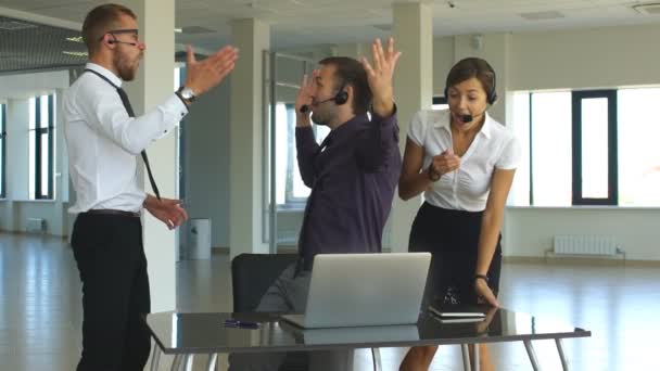 Groupe de gens d'affaires heureux en tenue décontractée intelligente regardant l'ordinateur portable et gestualisant — Video
