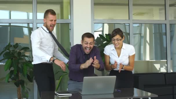 Gruppe glücklicher Geschäftsleute in schicker Freizeitkleidung blickt auf den Laptop und gestikuliert — Stockvideo