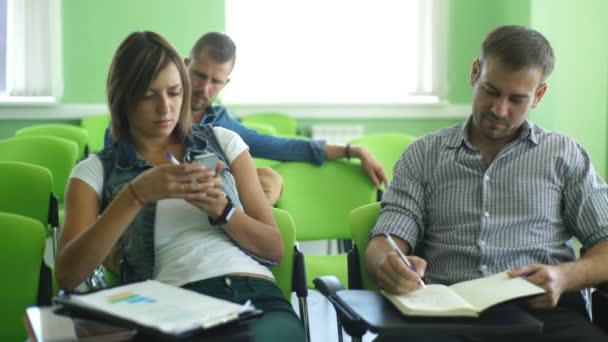 Studious young adults listening a lecturer in a classroom — Stock Video