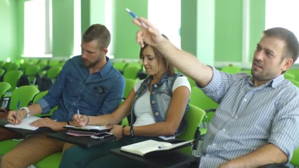 Три студента сидят за пультом — стоковое видео