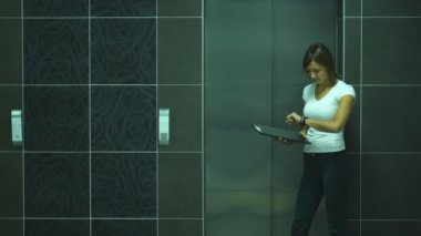 elvator için bekleyen ve ofis lobisinde konuşurken iki iş adamları.