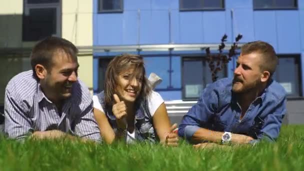 Trois étudiants couchés sur la pelouse barboter — Video