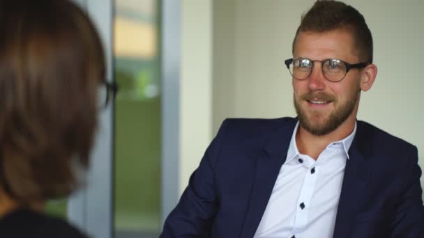 Young businessman discussing the terms of the contract with businesswoman in office — Stock videók