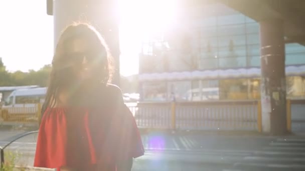 Beautiful girl in a red dress walking in the city — Stock Video