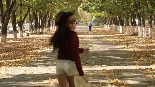 女の子は、カメラと笑顔から離れて歩く — ストック動画